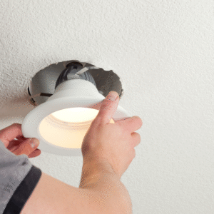 A person updating recessed lighting.