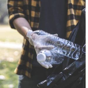 A man collecting empty plastic water bottles.
