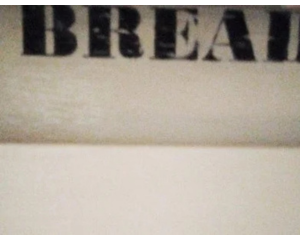 Paper rubbed off to reveal the word bread. 