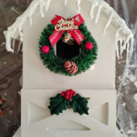 White birdhouse with wreath, icicles and garland