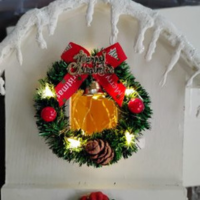 White birdhouse with wreath, fairy lights, icicles and garland