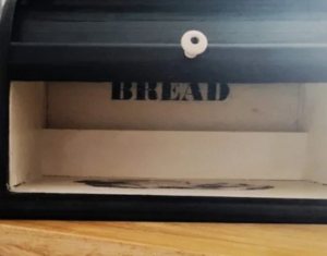 Inside of bread box with image of bread and a loaf of bread.