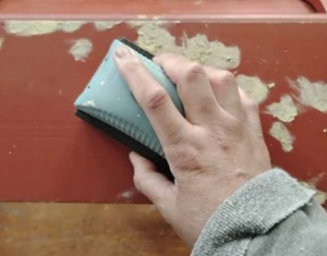 Sanding the filled holes of bread box.